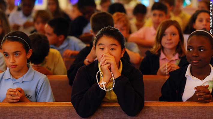 Students participate in a prayer service for victims of the Newtown, Connecticut, mass shooting at St. Rose of Lima School in Miami on Friday, December 21. (Joe Raedle / Getty Images)